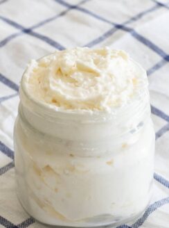 shea butter whipped body butter in glass mason jar on blue and white checker towel