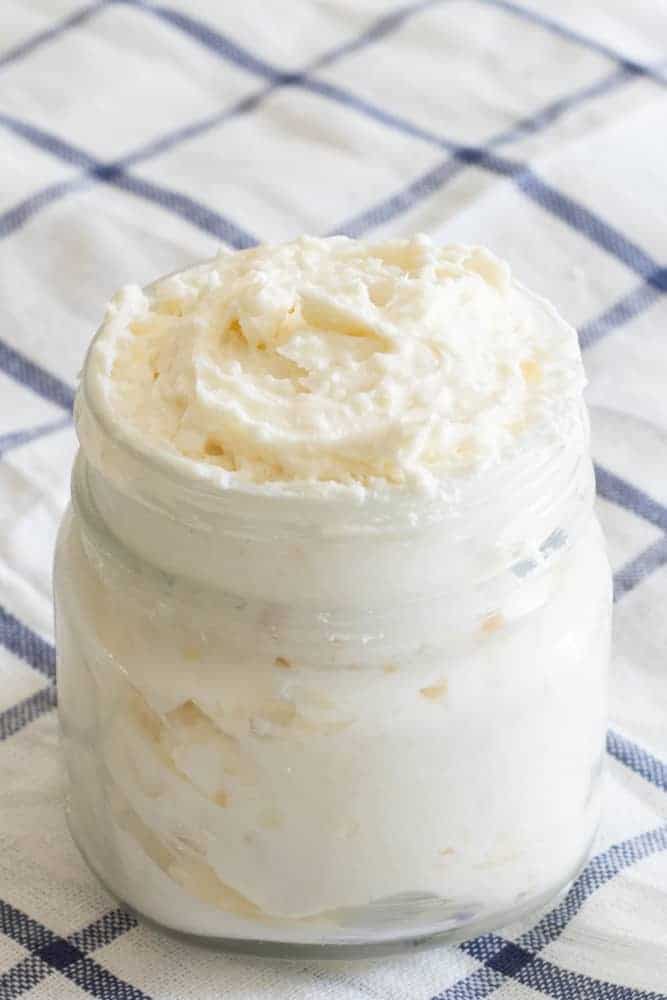 non-greasy shea butter whipped body butter in glass mason jar on blue and white checker towel