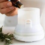 rosemary essential oil going in white diffuser