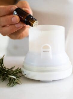 rosemary essential oil going in white diffuser