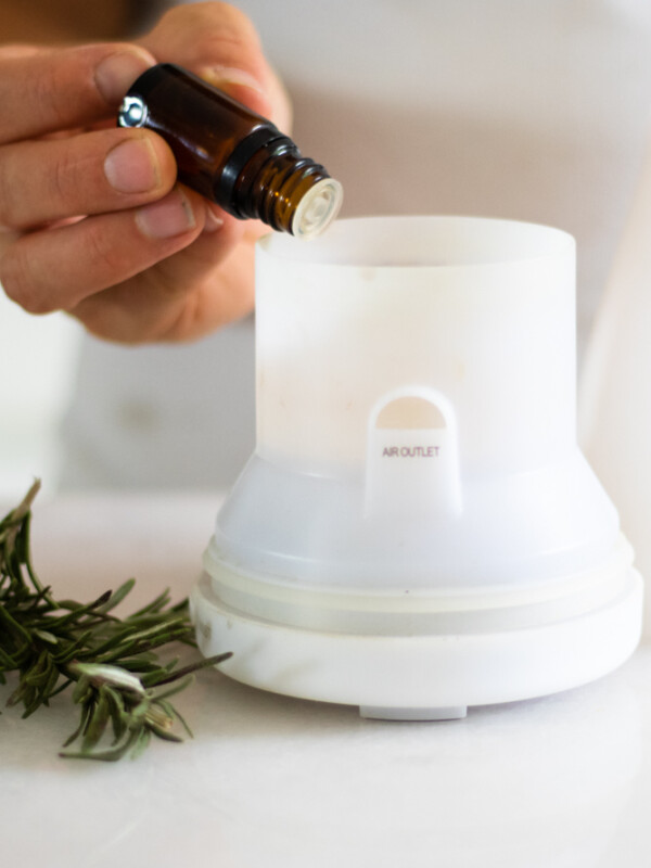rosemary essential oil going in white diffuser