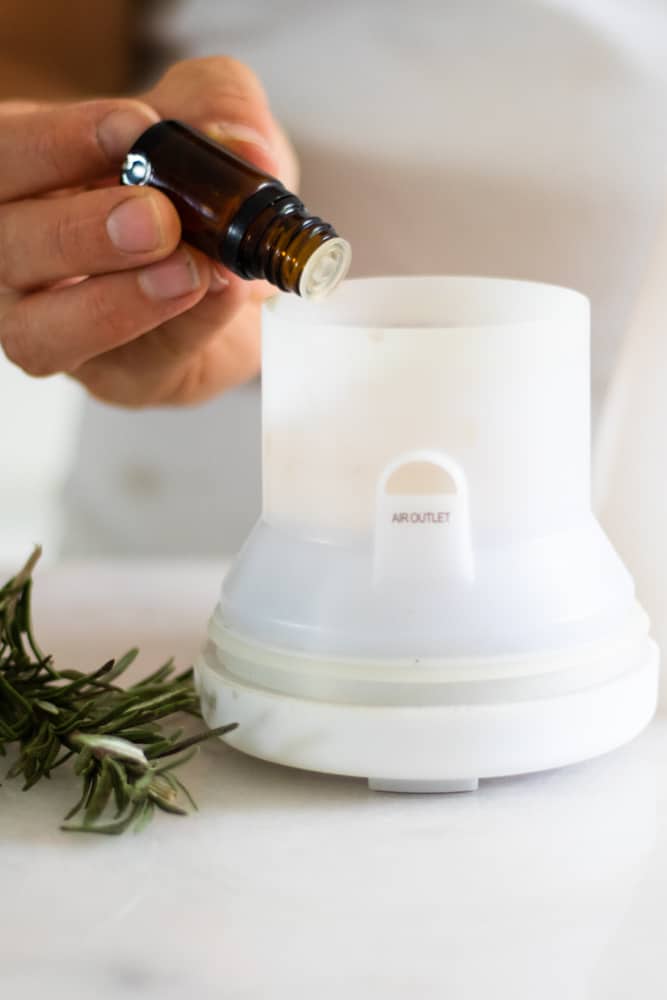 rosemary essential oil going in white diffuser