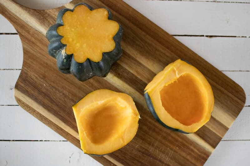 acorn squash cut in half on cutting board