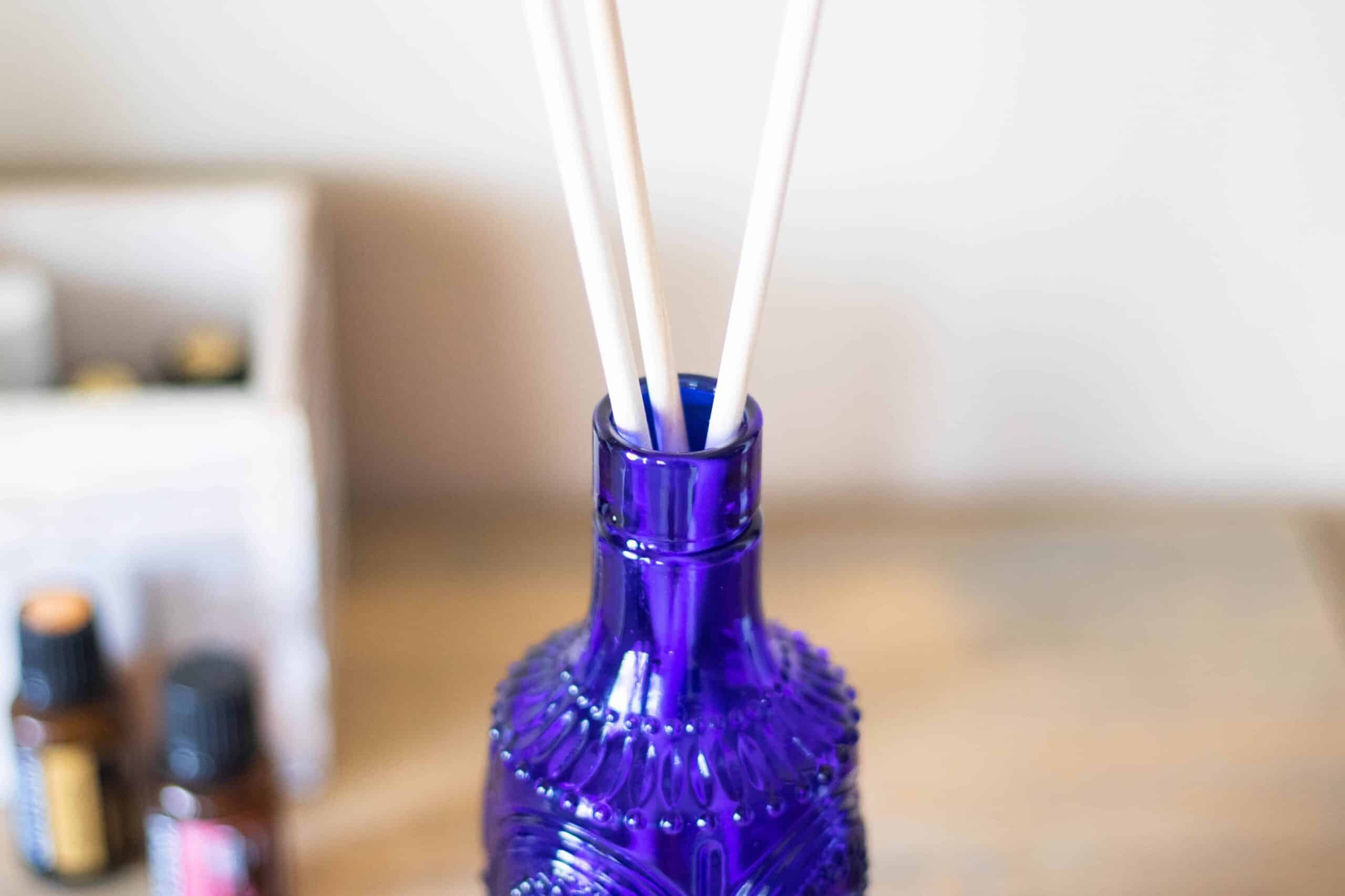 homemade reed diffuser in blue vase on corner table