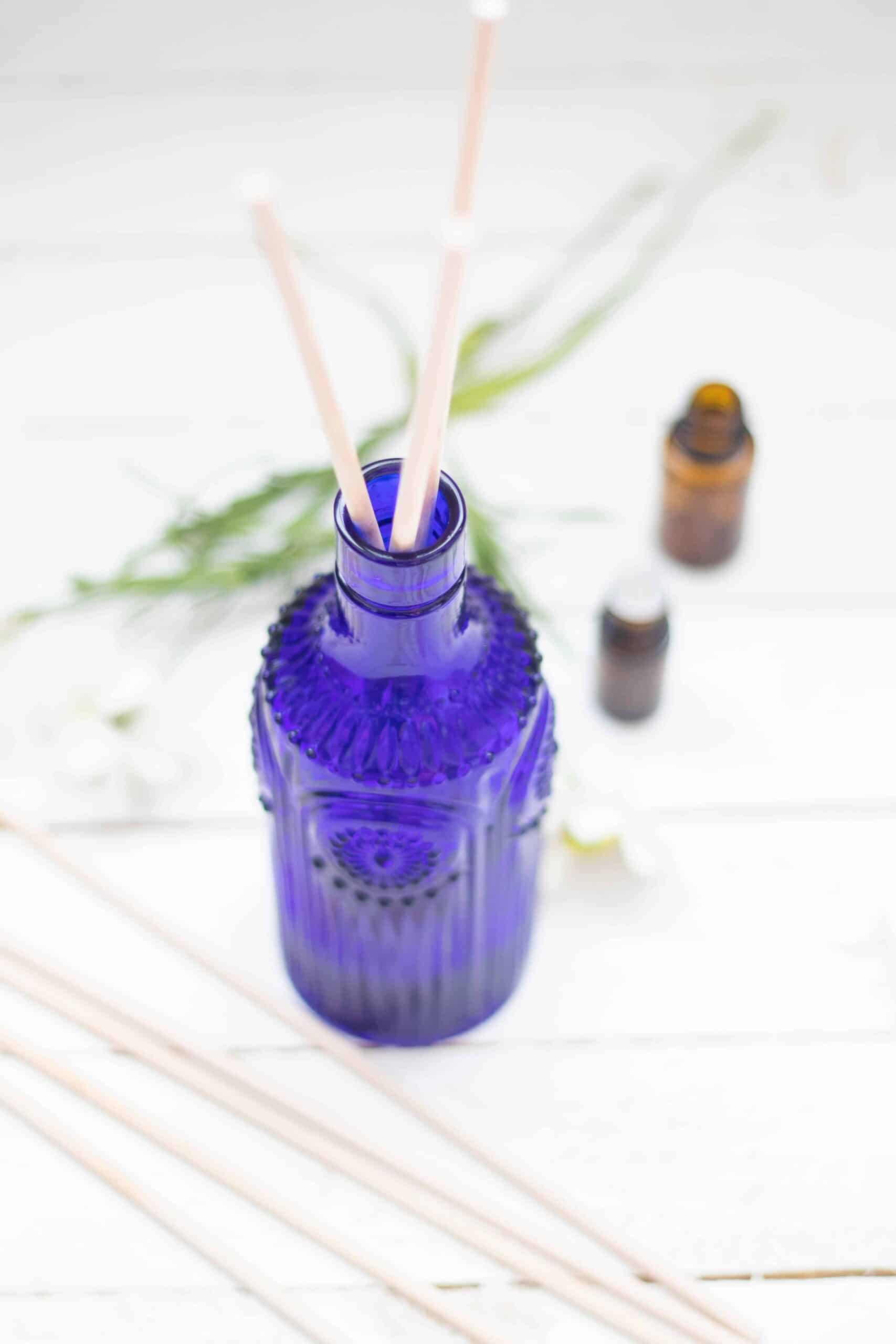 essential oil reed diffuser on white shiplap