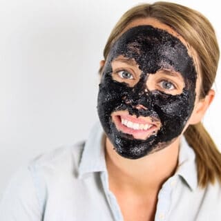 charcoal face mask on women's face