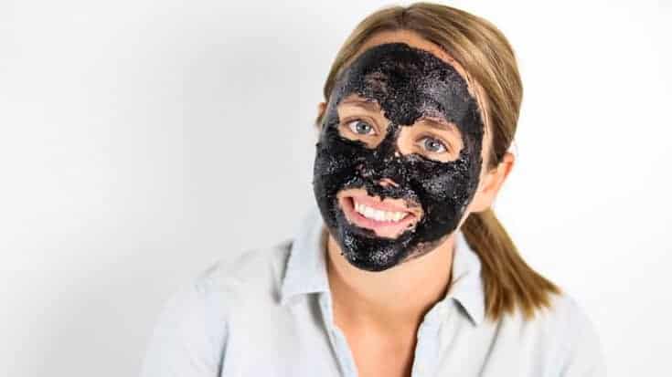 charcoal face mask on women's face