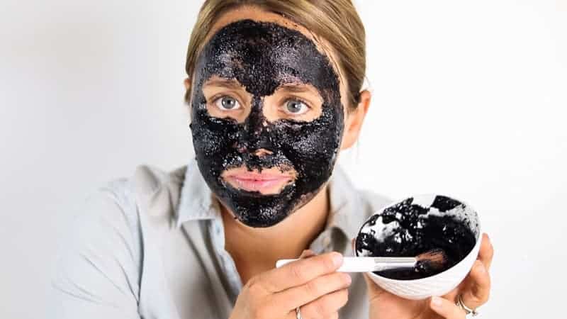 Using a makeup brush to apply peel off face mask.