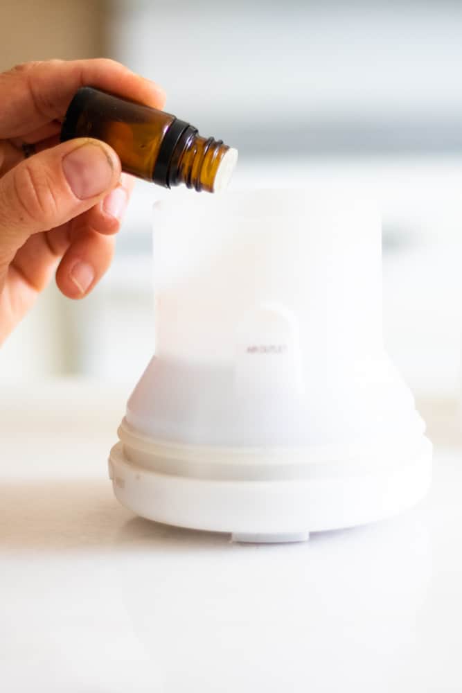 Adding essential oils to a clean diffuser.