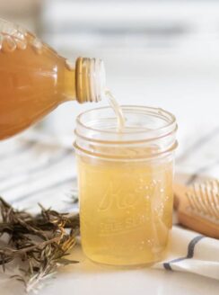 Pouring apple cider vinegar into mason jar.