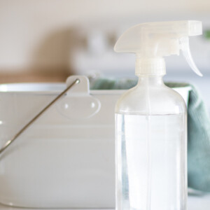 White cleaning caddy with non toxic spray bottle and blue cloth.