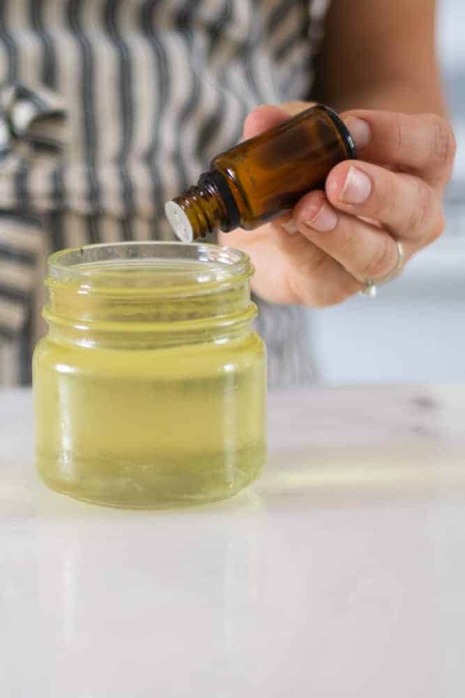 adding christmas essential oils to melted candle wax