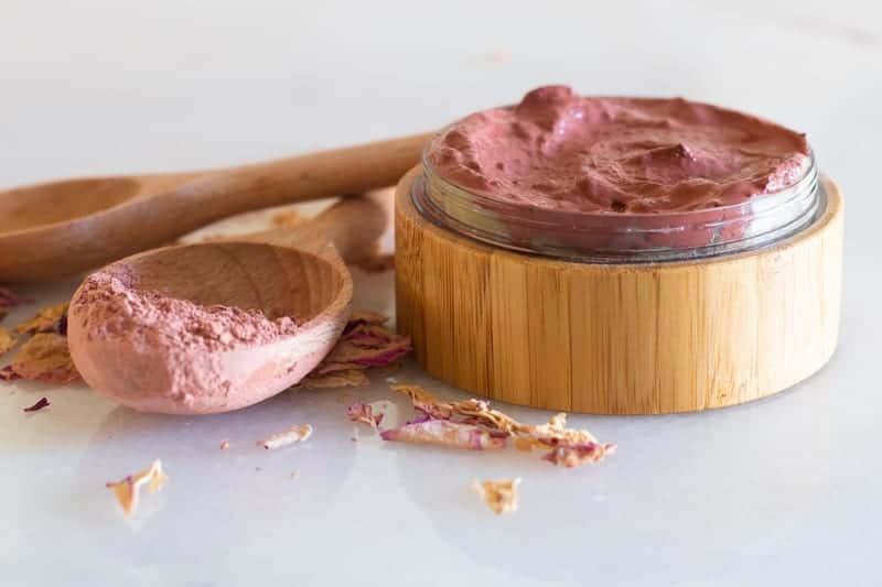 rose clay face mask in wooden container with a glass insert