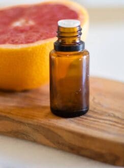 essential oil bottle in front of grapefruit