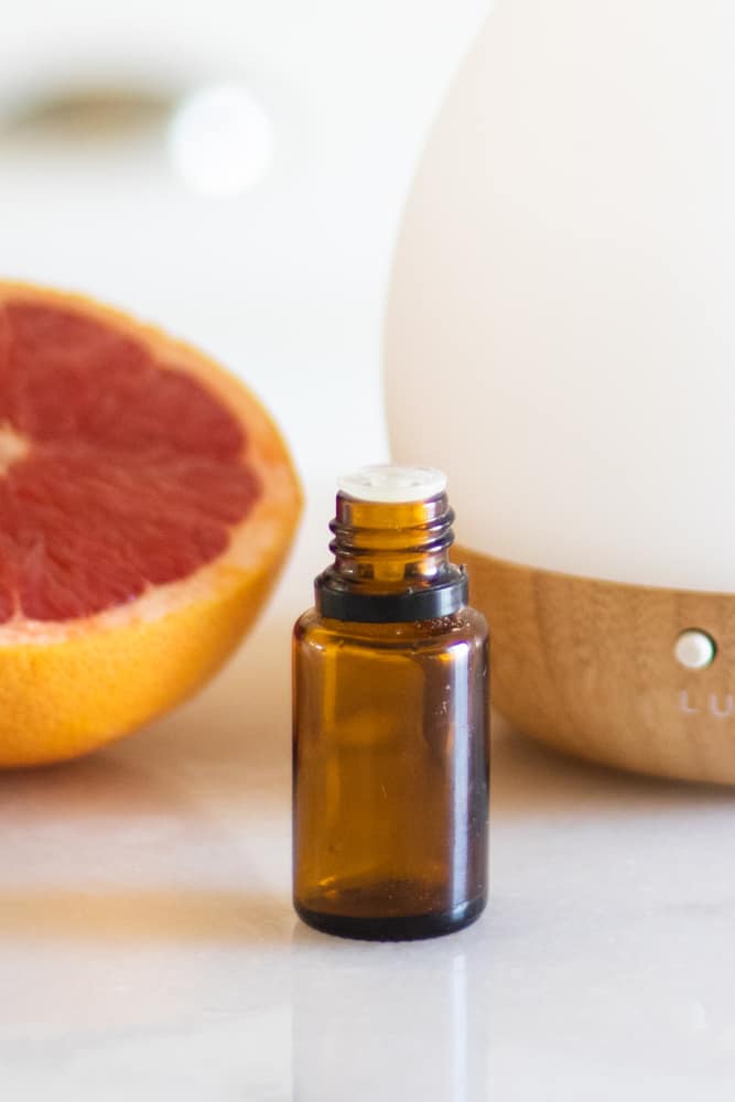 grapefruit essential oil bottle on white marble 