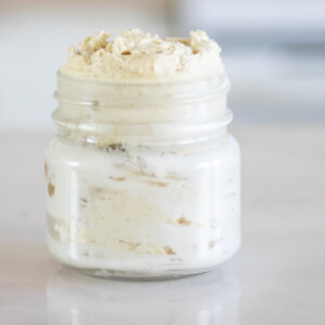 mason jar with homemade whipped body butter on white marble table