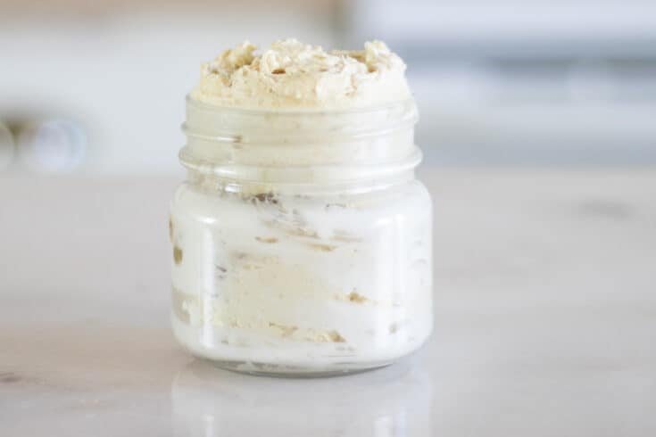 mason jar with homemade whipped body butter on white marble table