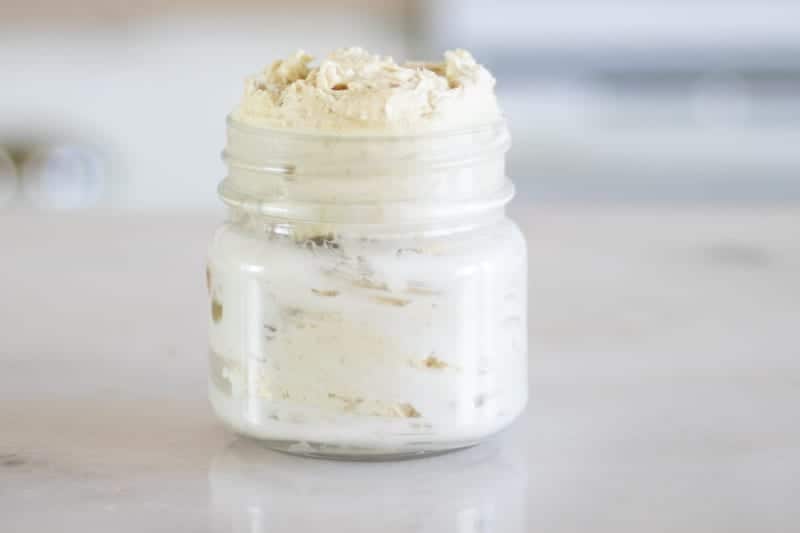 wide mouth mason jar of glowing skin whipped body butter overflowing out the top