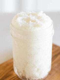 Whipped sugar scrub in mason jar on wooden board.