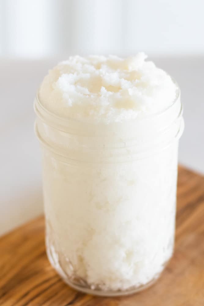 Whipped sugar scrub in mason jar on wooden board.