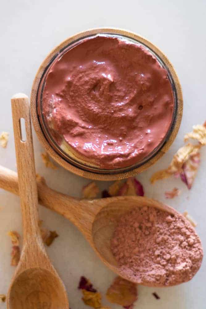 rose clay face mask with rose clay in wooden measuring spoon