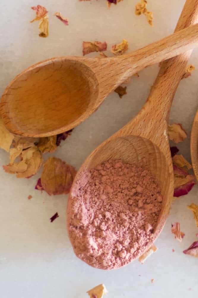 rose clay and apple cider vinegar in wooden measuring spoons 