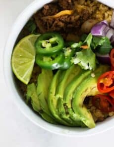 whole30 taco bowl with fresh toppings in white bowl.