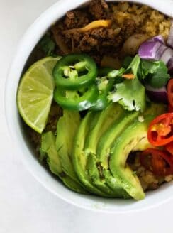 whole30 taco bowl with fresh toppings in white bowl.