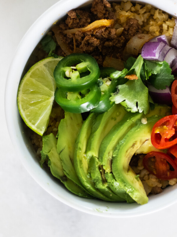 whole30 taco bowl with fresh toppings in white bowl.