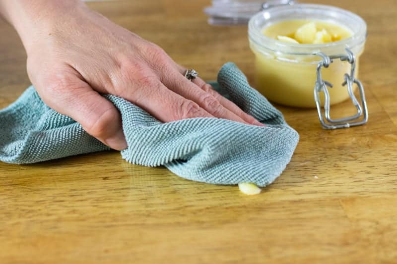 working in beeswax wood polish with a green microfiber cloth