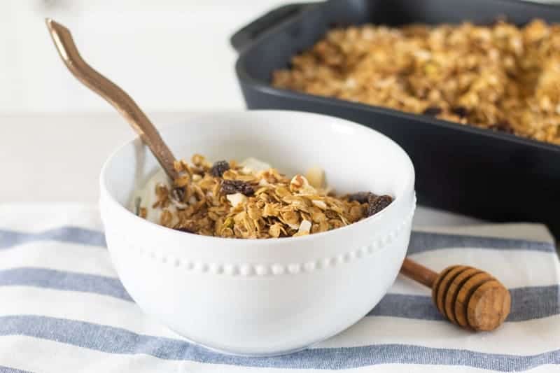 homemade sugar free granola in white bowl with yogurt