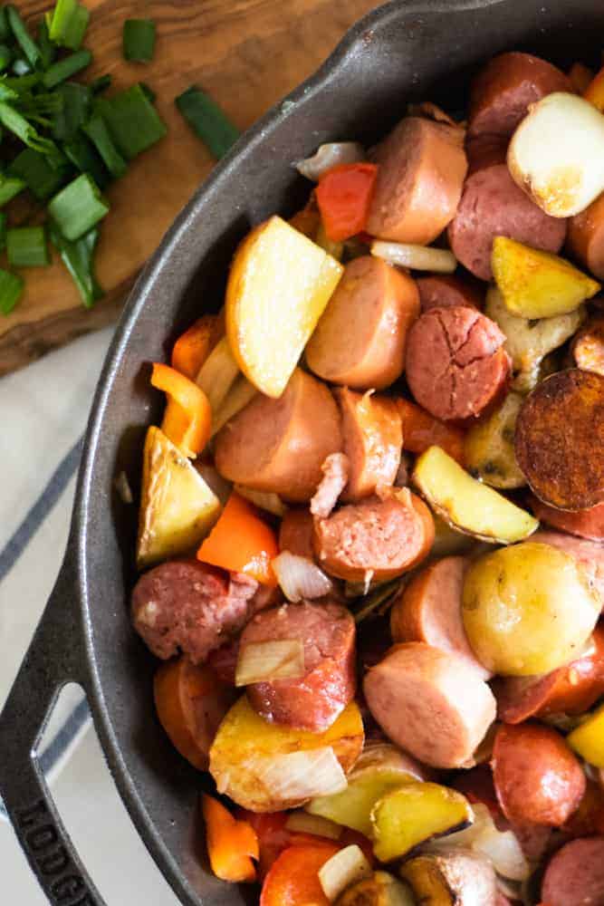 polish sausage and new potatoes in a cast iron skillet