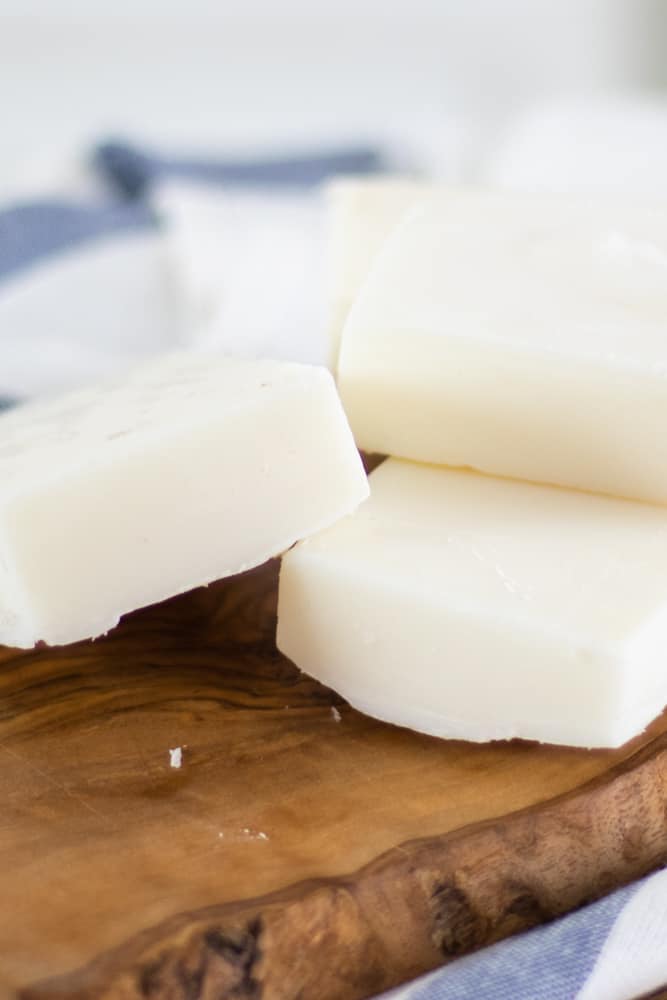 Homemade tallow soap bars curing on wooden board.