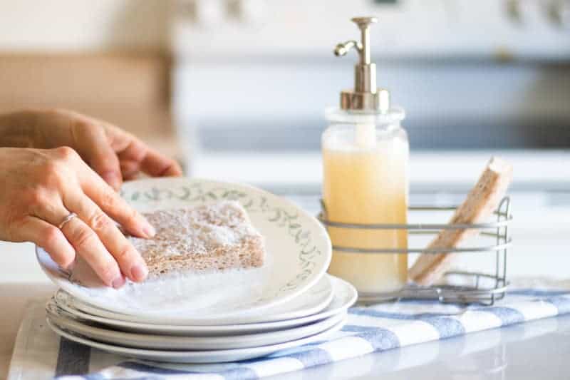 Washing a plate with homemade dish soap and a sponge. 