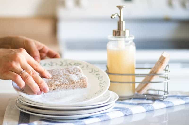 washing white plate with homemade dish soap 