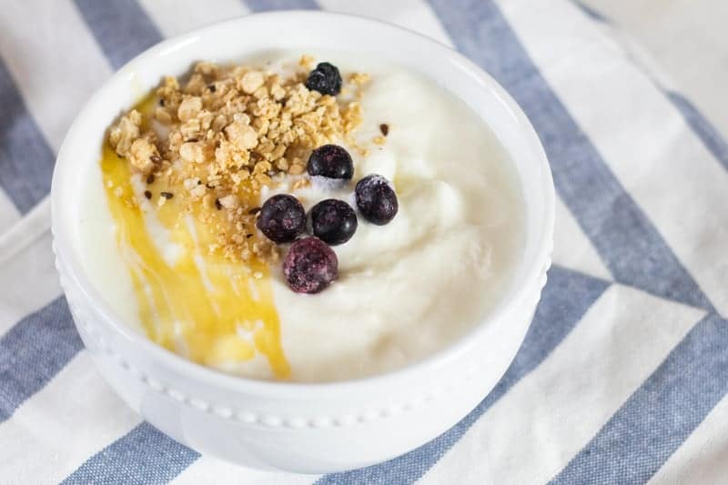 Bowl of freshly made yogurt on a blue and white towel.