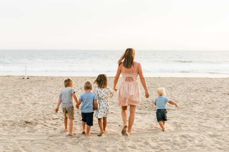 Women and kids walking on the beach. 