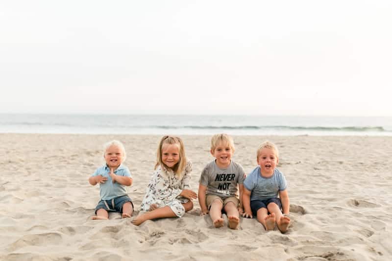 kids sitting on the beach.