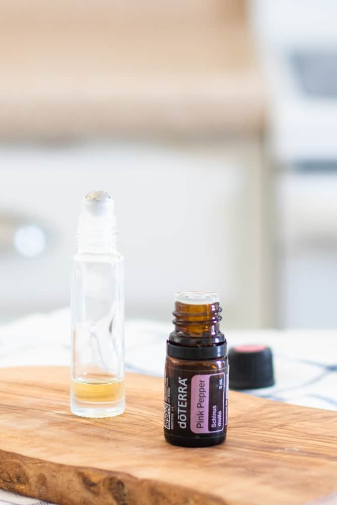 Homemade roller bottle of pink pepper essential oil.