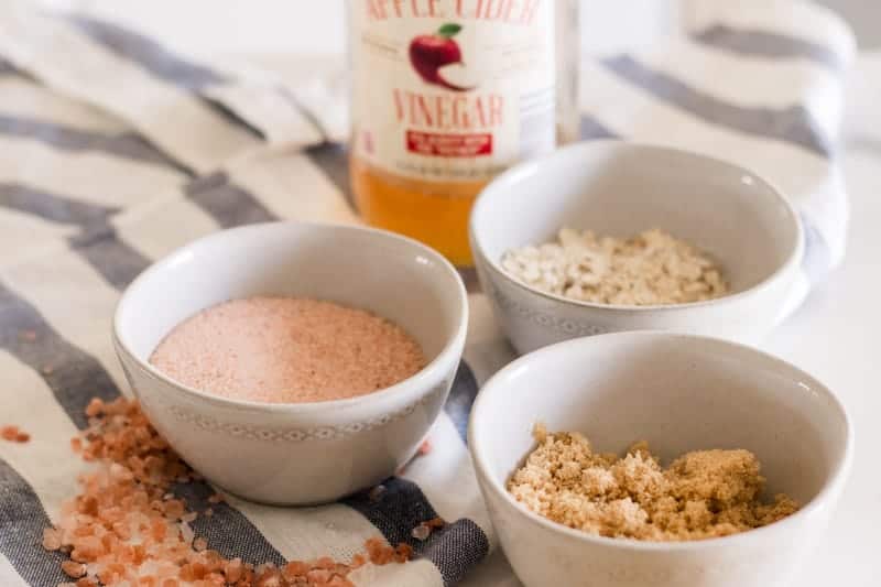 Three white bowls of salt, sugar, and oatmeal scalp scrub. 