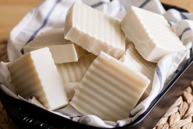 Shampoo bars in a black dishing dish lined with a white and blue tea towel.