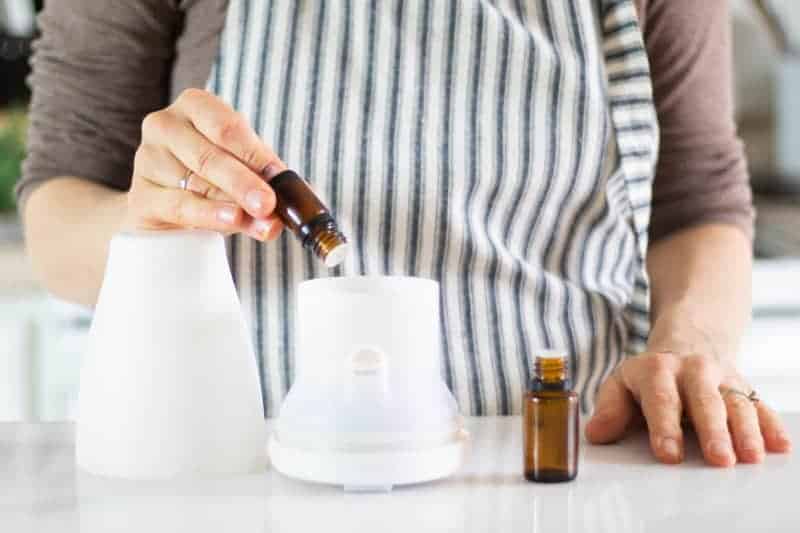 Women putting essential oils in a diffuser.