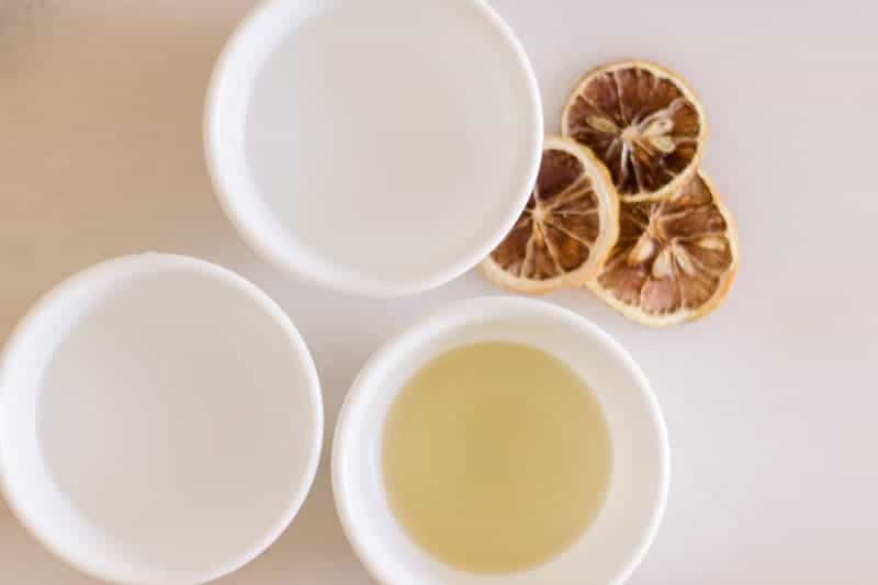 Three white bowls with water, vinegar, and olive oil in it. 