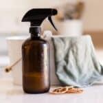 A bottle of dusting spray with a microfiber cleaning cloth.