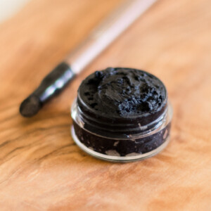 Homemade eyeliner in small glass jar with wooden applicator.