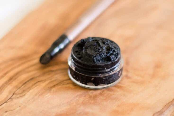 Homemade eyeliner in small glass jar with wooden applicator.