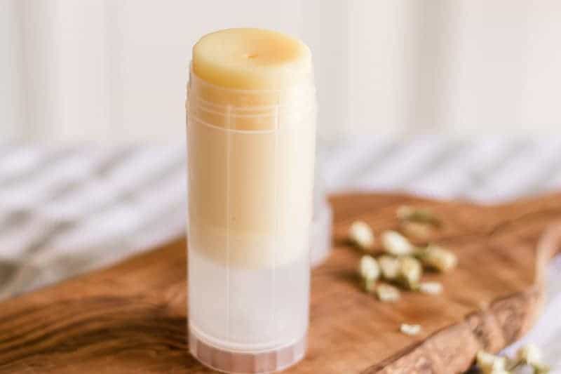 DIY foot balm in twist-up container on wood board. 