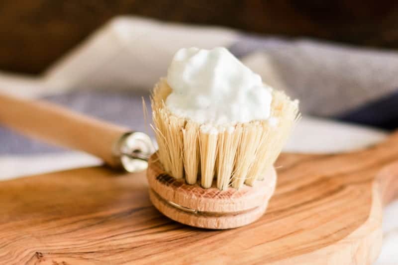 Foaming shaving cream on scrub brush. 