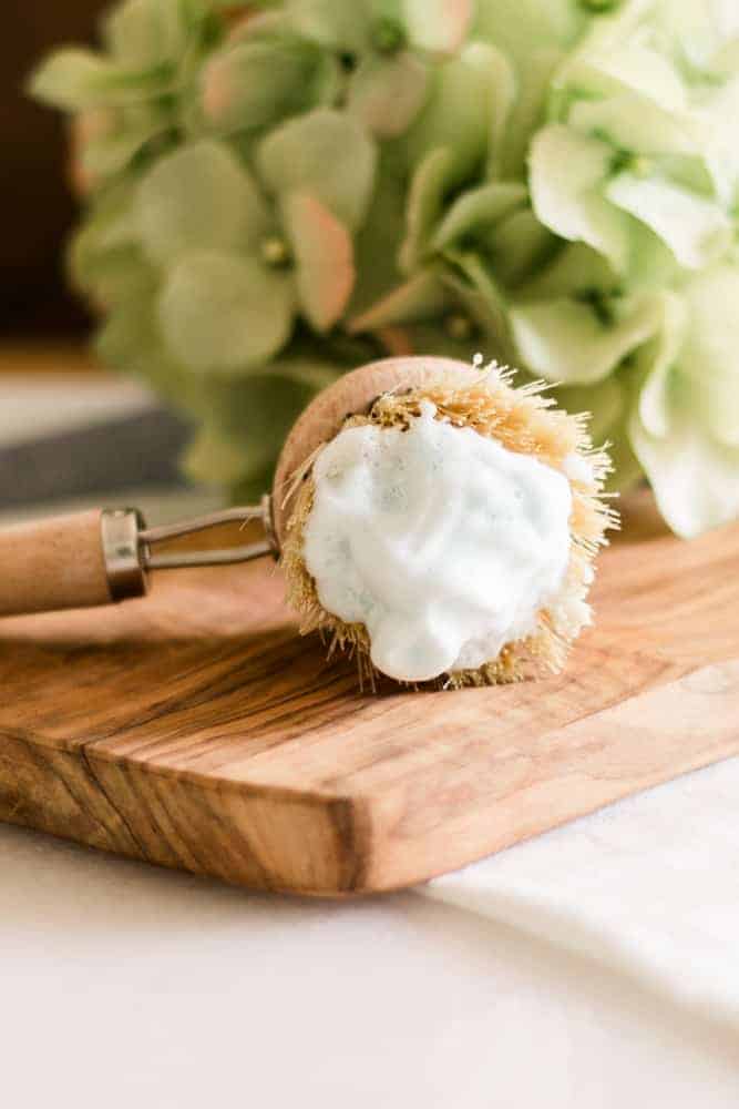 DIY foaming shaving cream on brush sitting on wood board. 