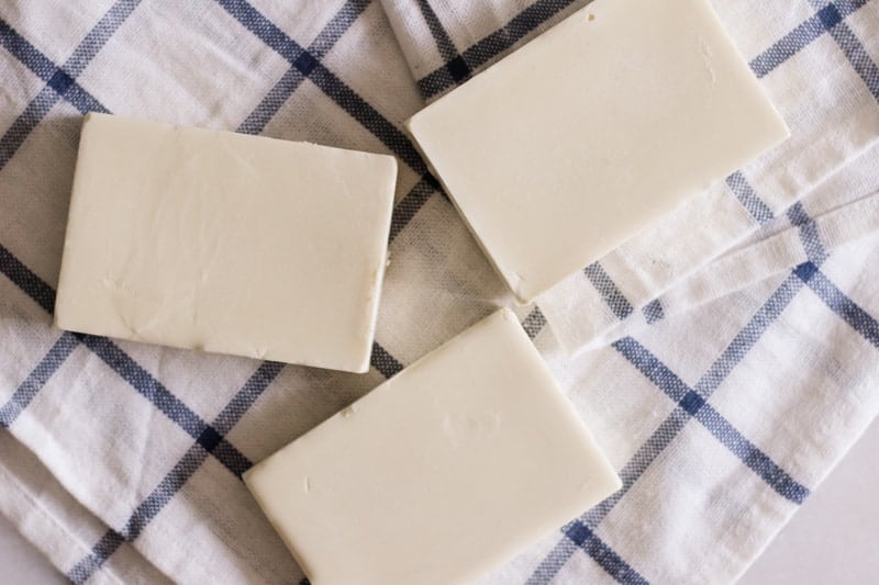 White sunscreen bars on white and blue tea towel. 